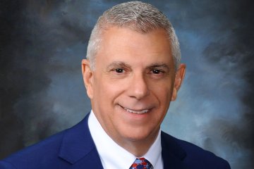 Anthony Picente in white shirt and blue suit jacket.